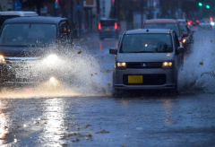 落ち葉の影響で冠水した道路を進む自動車(1日午前8時40分ごろ、西1南12で。塩原真撮影)
