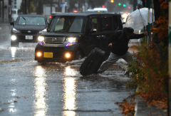 冠水した路面に漬かりながら進む歩行者(1日午前8時40分ごろ、西1南12で。塩原真撮影)