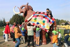 ナウマンゾウの親子模型にブランケットとマフラーを取り付ける園児ら