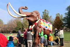 ナウマンゾウの親子模型にブランケットとマフラーを取り付ける園児ら