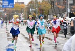 仮装したランナーが並んでゴール。悪天候ながら沿道の観客も声援を送った（２日午前１０時すぎ、塩原真撮影）