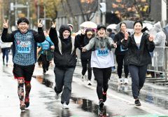 ピースをしながら並んでゴールに入るランナー（２日午前９時２０分ごろ、塩原真撮影）