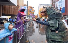 ティラノサウルスがティラノサウルスに応援。仮装したランナーが沿道の観客も声援を送った（２日午前８時半すぎ、塩原真撮影）