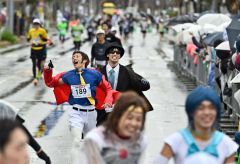 仮装したランナーがゴール。悪天候ながら沿道の観客も声援を送った（２日午前１０時すぎ、塩原真撮影）