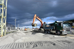 砂障害の砂利をトラックに移す作業を行う重機