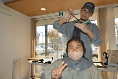 髪を切ってもらい笑顔を見せる施設利用者の女性