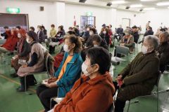 「劇場版　荒野に希望の灯をともす」を観賞し、尺八演奏に耳を傾ける来場者ら
