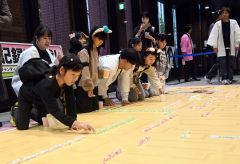 あめを並べる参加者。ハロウィーンに合わせ、仮装して参加