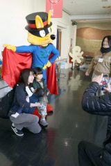 人気絵本のキャラクターと写真撮影する家族連れ(助川かおる通信員撮影)