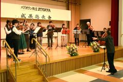 応援ゲスト２人を交えて全体演奏を披露する生徒ら（右は梅田さん）