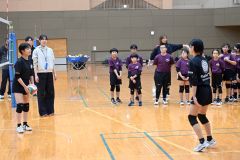 子どもたちのスパイク練習を見守る新鍋さん（左奥）