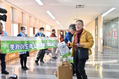 地元関係者らが横断幕を掲げて仁川からの旅行客らを出迎えた（１１日午後３時ごろ）