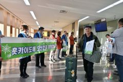 地元関係者らが横断幕を掲げて仁川からの旅行客らを出迎えた（１１日午後３時ごろ）