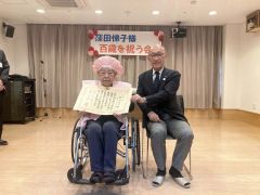 飯田町長（右）から内閣総理大臣の祝い状などが伝達された窪田さん