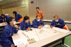 災害を想定し、本部と無線で連絡を取り合う団員たち