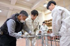 鉄筋を結束線でつなぐ作業を体験する生徒たち