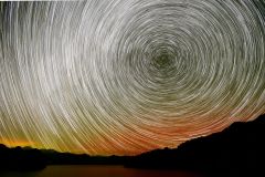 オーロラと星の軌跡（１２日午後９時１５分から１時間撮影し比較明合成、上士幌町の糠平湖畔で。塩原真撮影）