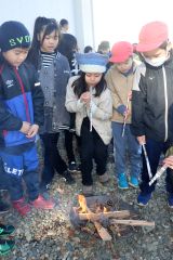 火起こしを体験する児童ら