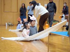 シーツの上で笑顔を見せる子どもたち
