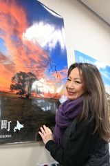 町役場のハルニレのポスターにサインする八神さん