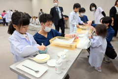 真剣な表情で調剤体験をする子ども