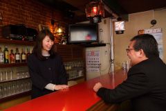 カウンターで山田支店長（右）と談笑する杉村さん
