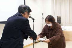 加藤代表（左）からグランプリの表彰状を受け取る松原さん