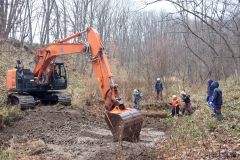 堆積した土砂を重機で上げる様子（平田建設提供）