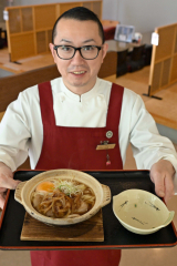 鍋焼きうどんをＰＲする佐藤料理長（須貝拓也撮影）