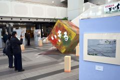 「いきる」をテーマとした共同作品を鑑賞する来場者（２０日午前１０時１５分ごろ、とかちプラザ。須貝拓也撮影）