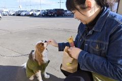 愛犬と一緒に地場産サツマイモを使った焼き芋を味わう買い物客（２２日午前９時半ごろ撮影）