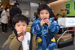 焼きたての地場産サツマイモを頬張る子ども（２２日午前１１時ごろ撮影）