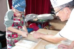 そば切りを体験する参加者（左）と指導する朝倉代表