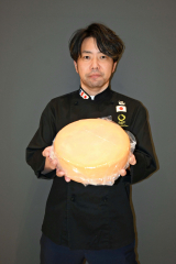 銀賞を受賞したチーズ「ａｇｅ０２　Ｒａｃｌｅｔｔｏ」を手にする七海専務