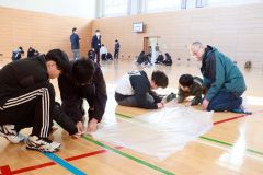 斎藤准教授からのアドバイスをを受けながら、熱気球作りに挑戦する児童ら