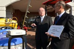 下堀校長に自動操舵機の特徴を説明ずる菅原代表（左）