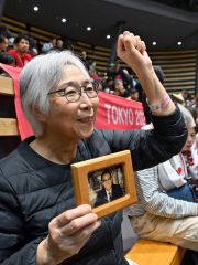 遺影を持ち観戦する坂本さんの母瑞恵さん