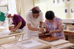 利用者にそば打ちを手ほどきする沼田代表