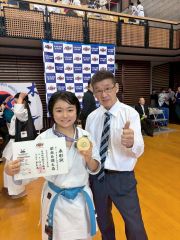 優勝のメダルと賞状を手にする真統館の小林みひろ。右は延藤勉館長