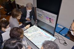 地形を凹凸で再現したスクリーンに芽室町の地図が映し出され、浸水シミュレーションを行った