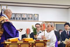 得度式で手を合わせる（左から）大和さんと武司さん
