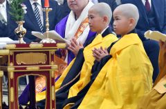 得度式で手を合わせる（左から）仁道さんと孝司さん
