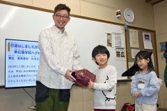 小川さんからグローブを受け取り笑顔の児童