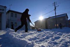 早朝から除雪に追われる市民(4日午前8時20分ごろ。帯広清流東1で。金野和彦撮影)