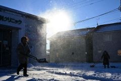 強風で雪が舞う中、除雪に追われる市民(4日午前8時20分ごろ。帯広清流東1で。金野和彦撮影)