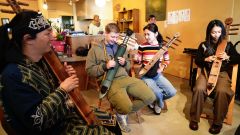 アイヌの伝統楽器「トンコリ」の演奏を体験する参加者