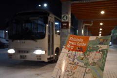 スキー場とまちなかを結ぶシャトルバスと、乗客向けに作製した英語のまちなかガイドマップ