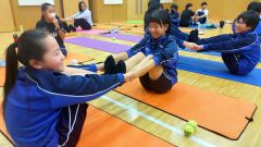 アーサナに基づいたストレッチに挑む生徒たち