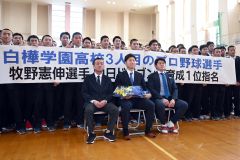 全校生徒との記念撮影に納まる牧野投手(前列中央、須貝拓也撮影)