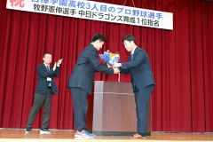 野球部で副キャプテンを務めた大西遙斗さん(3年、左)から花束を受け取る牧野投手(須貝拓也撮影)